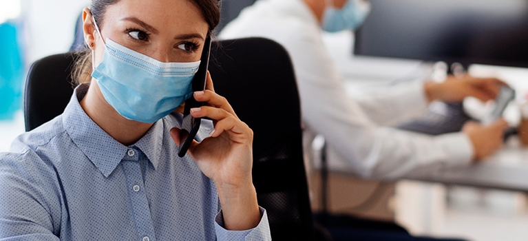 Woman working in office with mask on